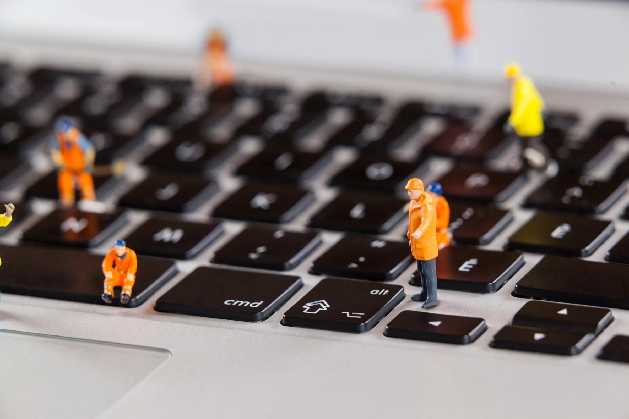 Osoba przy biurku aktualizuje stronę internetową na laptopie